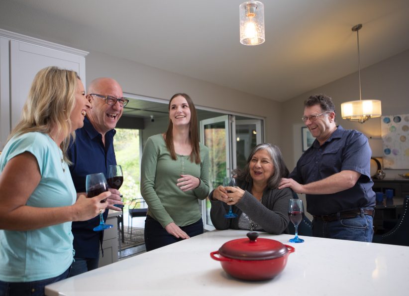 Family and friends gathered around a single red pot on the kitchen counter. Because staging.