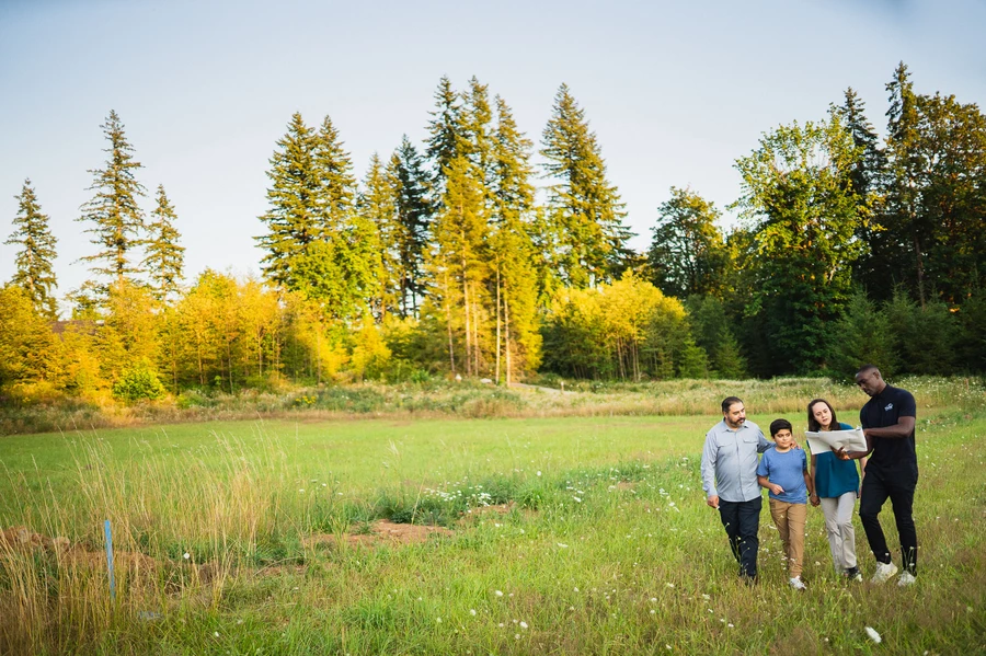Engineer and family outdoors reviewing architectural plans.
